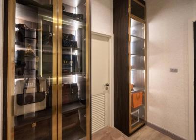 Modern walk-in closet with glass doors and organized shelves