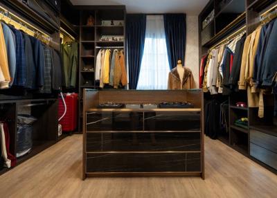 Spacious walk-in closet with organized clothing and wooden finishes
