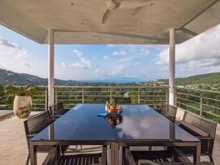 Spacious balcony with a view of the hills and a dining area
