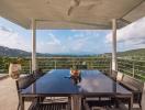 Spacious balcony with a view of the hills and a dining area