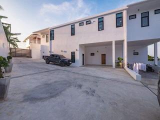 Modern two-storey residential building with spacious driveway and vehicles