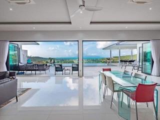Spacious modern living room with large glass doors opening to a balcony with a picturesque view