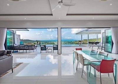 Spacious modern living room with large glass doors opening to a balcony with a picturesque view