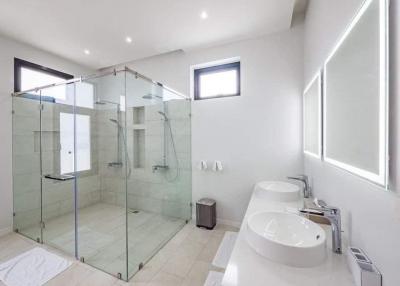 Spacious modern bathroom with large walk-in shower and white interiors