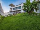 Exterior view of a multi-level modern home with lush green lawn