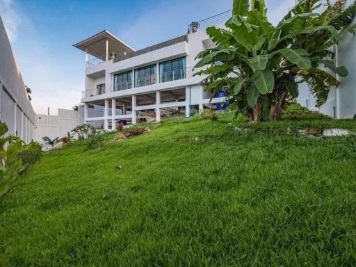 Exterior view of a multi-level modern home with lush green lawn