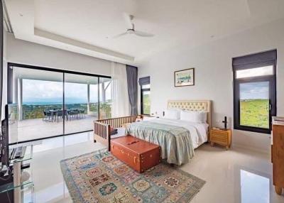Spacious bedroom with large windows and mountain view