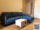 Modern living room interior with large blue sofa and wooden flooring