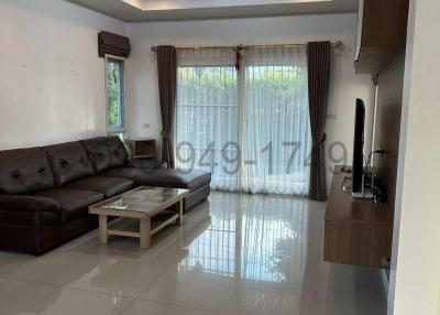Contemporary living room with brown sofa and glossy white floor tiles