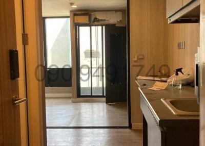 Open floor plan interior of apartment with kitchen and view towards the balcony