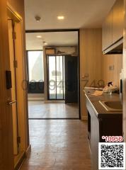 Open floor plan interior of apartment with kitchen and view towards the balcony