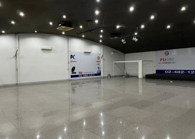 Spacious commercial interior with high ceiling and reflective floor