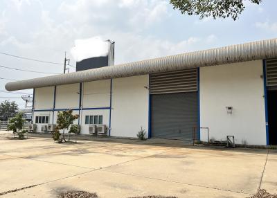 Exterior view of an industrial warehouse building with multiple rolling shutter doors