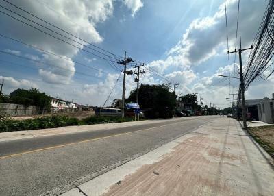 Suburban road with utility poles and clear sky