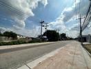 Suburban road with utility poles and clear sky