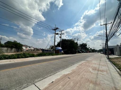 Suburban road with utility poles and clear sky