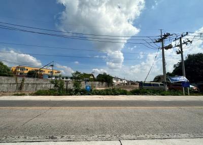 Street view of a residential neighborhood under a clear blue sky with clouds