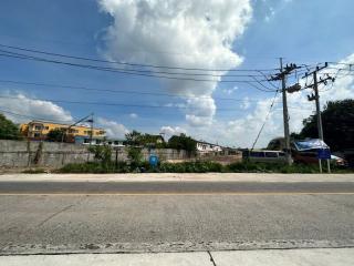 Street view of a residential neighborhood under a clear blue sky with clouds