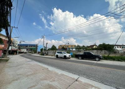 Street view with residential buildings under a clear blue sky