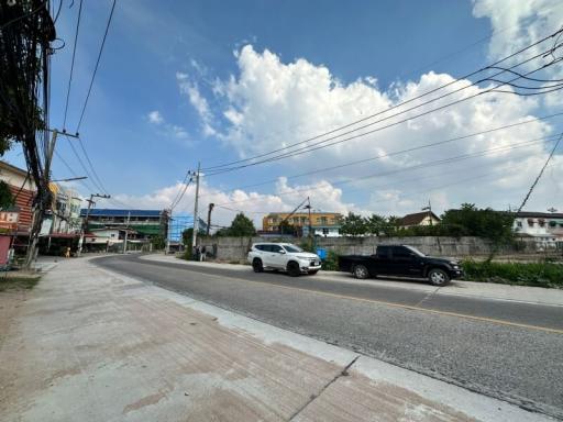 Street view with residential buildings under a clear blue sky