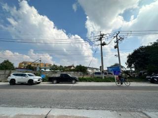 Street view of the property with cars and a cyclist