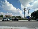 Street view of the property with cars and a cyclist