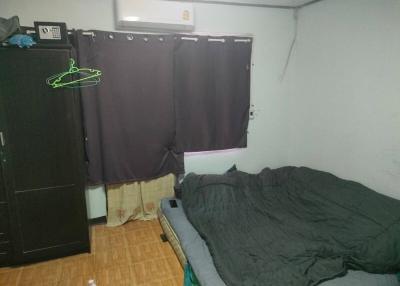 Cozy bedroom with dark curtains and unmade bed