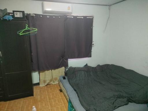 Cozy bedroom with dark curtains and unmade bed