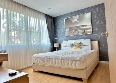 Modern bedroom with large bed and artistic wall decor