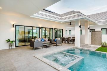 Modern patio area with outdoor seating and dining space overlooking a swimming pool