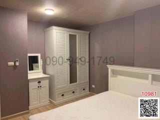 Cozy bedroom with purple walls and white furniture