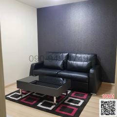 Contemporary living room with a black leather sofa and a modern coffee table