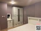 Spacious bedroom with large white wardrobe and elegant purple walls