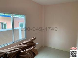 Bright empty bedroom with large window and covered items