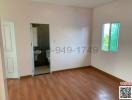 Spacious bedroom with hardwood floors, a large window, and an en suite bathroom