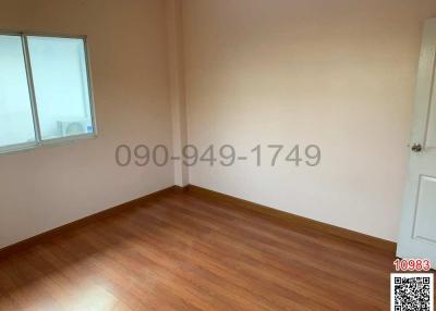 Empty bedroom with hardwood floor and a window