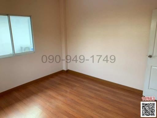 Empty bedroom with hardwood floor and a window