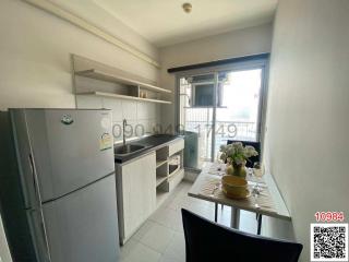 Compact modern kitchen with stainless steel appliances and natural light