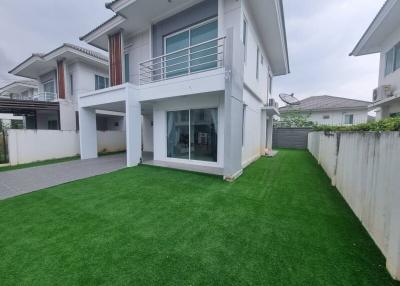 Modern two-story house with lush green lawn and spacious design