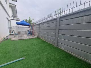 Spacious backyard with artificial grass and patio area
