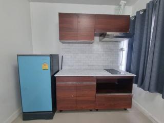 Compact modern kitchen with wooden cabinets and a blue refrigerator