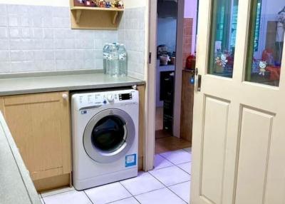 Compact kitchen space with white goods and tiled flooring