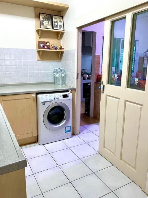 Compact kitchen space with white goods and tiled flooring