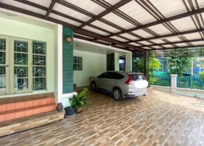 Spacious covered carport with tiled flooring and a modern vehicle parked