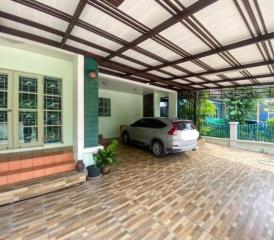 Spacious covered carport with tiled flooring and a modern vehicle parked