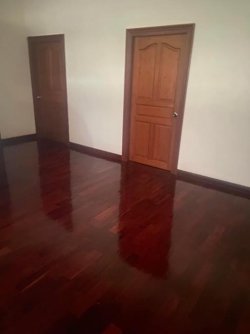 Polished wooden floor in a room with two closed wooden doors
