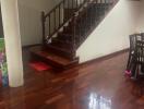 Elegant wooden staircase with polished hardwood floors in a well-lit home interior