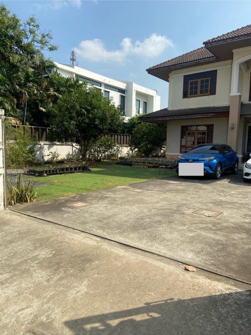 Spacious driveway with house and parked cars