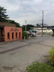 Front view of a commercial building with parking lot and street view