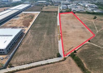 Aerial view of a large, empty land plot for sale with boundaries marked in red